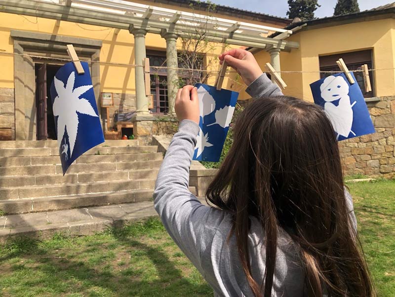 Niña colgando fotografias